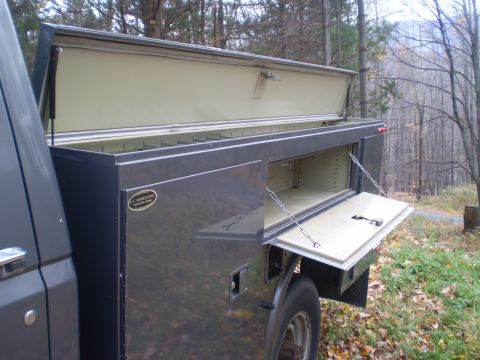 1979 Ford Bronco - This truck bed utility body has multiple compartments with the doors open, revealing storage space.