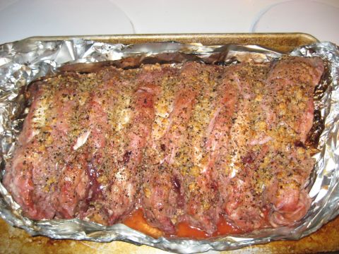 1978 Ford Bronco - A seasoned rack of ribs is prepared for cooking in a foil-lined baking pan.