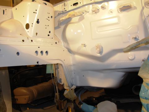 1991 Ford Taurus - The white painted engine bay frame shows structural details and numerous holes, suggesting ongoing work or preparation.
