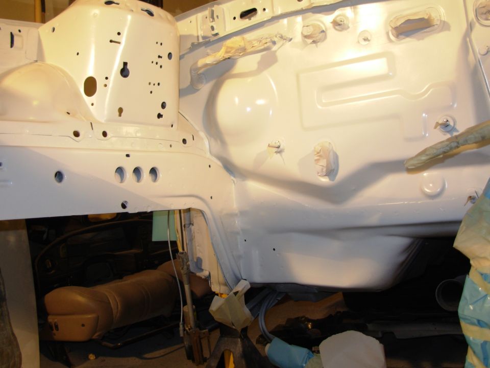 White painted engine bay frame with visible holes and structural components