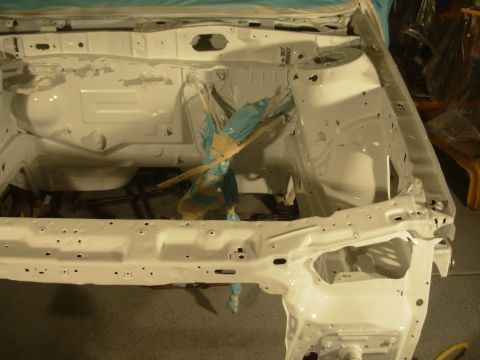 1991 Ford Taurus - The bare metal frame of a car's engine bay, recently painted white.