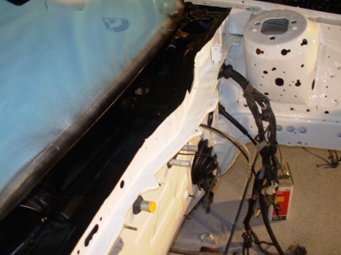 1991 Ford Taurus - A partially restored engine bay shows white painted metal and a black painted inner fender with a complex wiring harness.
