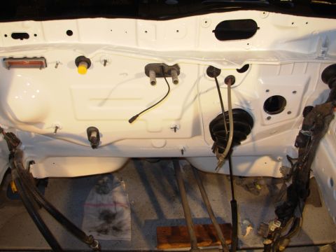 1991 Ford Taurus - The firewall of an engine bay, showing wiring harnesses and the brake booster, likely during a restoration or build.