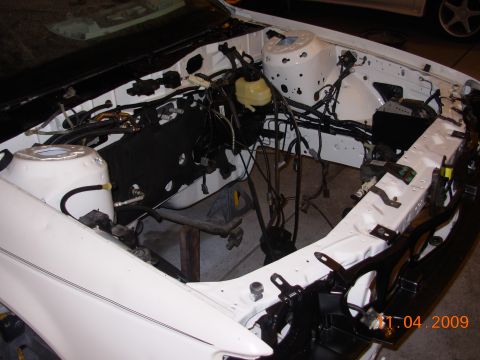 1991 Ford Taurus - The engine bay of a 1991 Ford Taurus is shown during a build-up process, revealing exposed wiring and components.