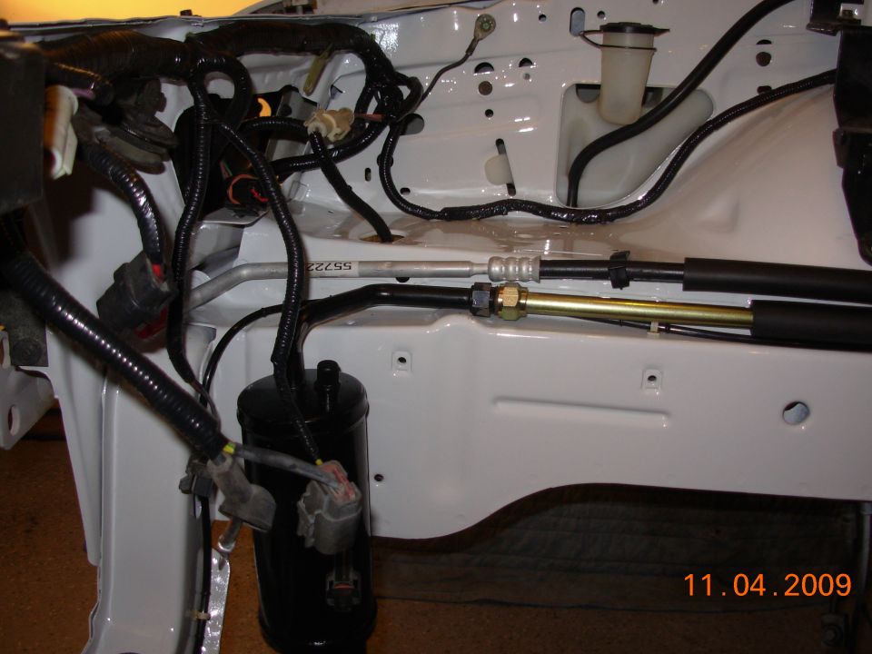 engine bay with wiring harnesses and metal hoses