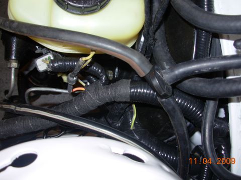 1991 Ford Taurus - Engine bay wiring harness and a yellow fluid reservoir are visible in this close-up shot.