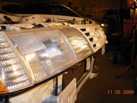 1991 Ford Taurus - The front end of a car is shown with its headlights and grille removed, revealing the underlying structure.