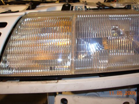 1991 Ford Taurus - Close-up of the front headlights and bumper of a 1991 Ford Taurus.