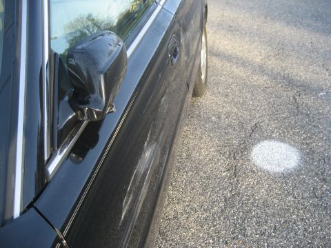 1997 Acura TL - The side profile of a black sedan is visible, with a focus on the door and side mirror.