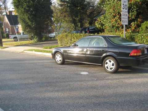 1997 Acura TL - Side profile of a black 1997 Acura TL sedan parked on a residential street.