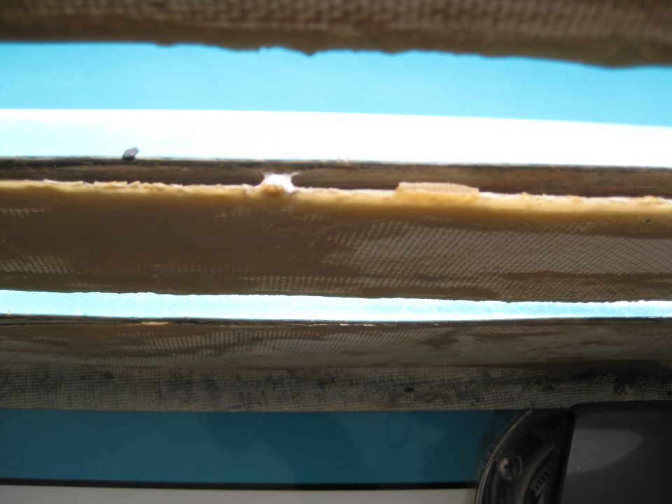Boat hull interior showing layered fiberglass and foam construction with a blue exterior visible below