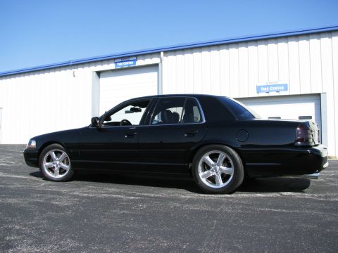 2003 Mercury Marauder - Side view of a black 2003 Mercury Marauder parked in front of a commercial building.
