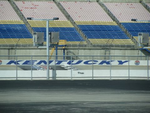 2003 Mercury Marauder - Grandstands with blue and yellow seats overlook a race track with a "KENTUCKY" banner.