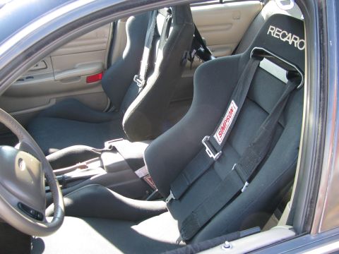 2003 Mercury Marauder - The interior of a car shows racing seats and safety harnesses, with visible branding from Recaro and Simpson.