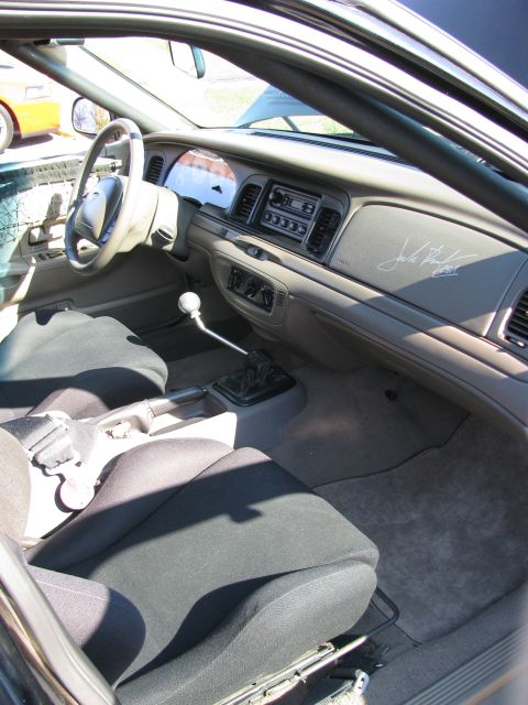 2003 Mercury Marauder - The interior of a car is shown, bucket seats, a manual transmission shifter, and the dashboard.