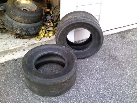 1969 Ford Mustang - Two racing tires are shown in front of a garage door.