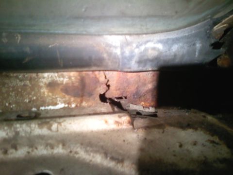 1969 Ford Mustang - Close-up view of heavily rusted metal, likely from a vehicle's undercarriage, showing significant deterioration.