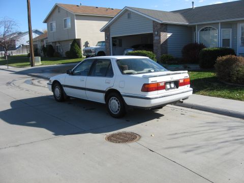 1989 Honda Accord - A white 1989 Honda Accord is parked on a residential street in front of a house.