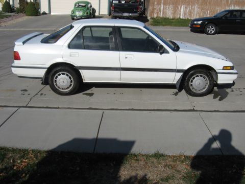 1989 Honda Accord - A white 1989 Honda Accord sedan is parked on a driveway, with a green Volkswagen Beetle and a black pickup truck in the background.