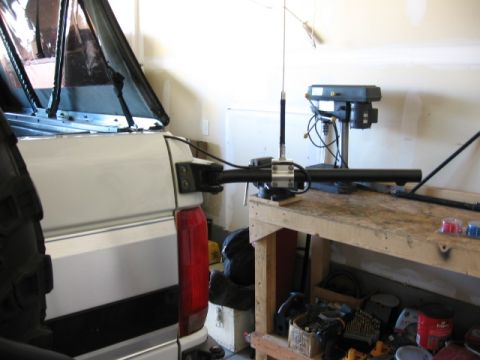 1995 Ford Bronco - The rear of a white pickup truck is shown with a soft top and an antenna mount. A drill press is visible in the background.