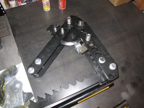 1996 Ford Bronco - A black tube bender tool, likely for automotive work, is shown on a metal surface with a measurement gauge nearby.