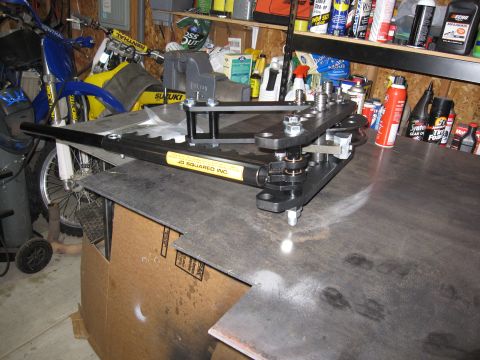 1996 Ford Bronco - JD Squared Inc. pipe bender tool is shown on a workbench in a garage setting.