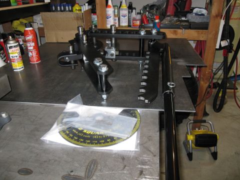 1996 Ford Bronco - Various automotive parts and tools are laid out on a metal workbench, including a protractor and spray cans.