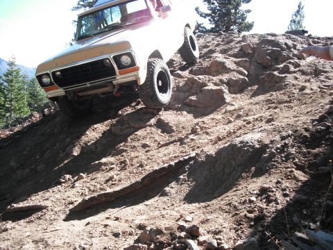 1991 Ford Bronco - Ford Bronco navigating a challenging off-road trail with steep inclines and loose rocks.