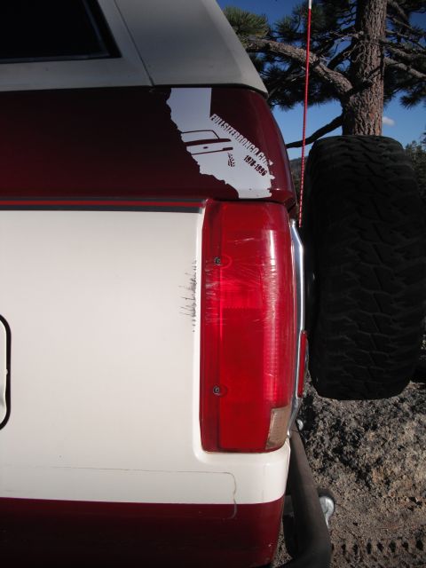 1991 Ford Bronco - The rear of a red and white Ford Bronco is visible, with a spare tire mounted externally.