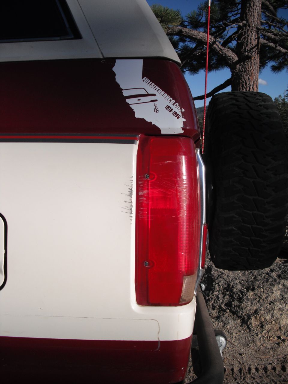 Red and white Ford Bronco rear quarter panel with a spare tire mounted on the back