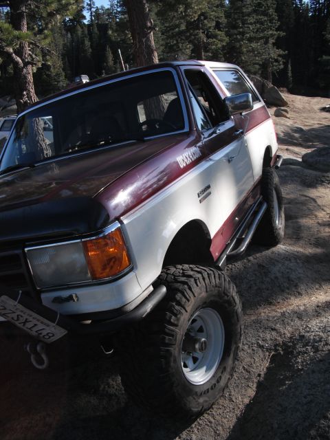 1991 Ford Bronco - This 1991 Ford Bronco features a two-tone maroon and white paint scheme and is equipped with off-road tires.