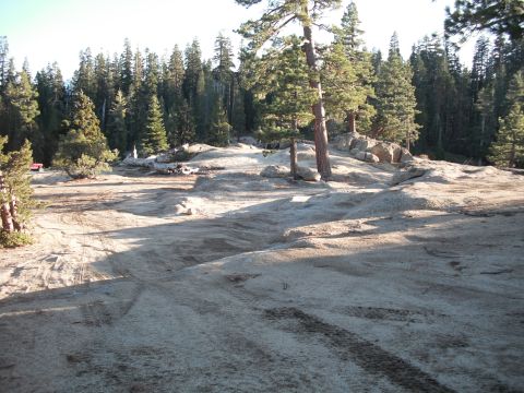 1991 Ford Bronco - A red vehicle is visible in the distance on a rocky, wooded terrain.