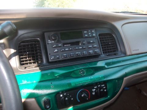 2004 Ford Crown Victoria - Interior view of a 2004 Ford Crown Victoria, highlighting the dashboard with its factory radio and green painted accents.
