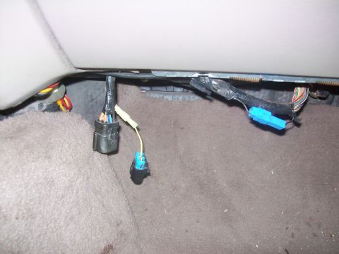 2004 Ford Crown Victoria - Close-up of vehicle wiring harness connectors and cables under the dashboard.