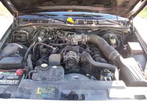 2004 Ford Crown Victoria - The engine compartment of a 2004 Ford Crown Victoria is open, revealing the V8 engine and its components.