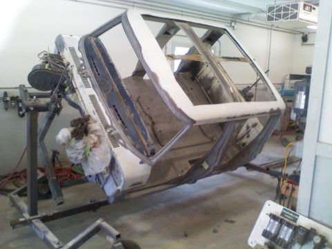 1979 Ford F-250 - Vehicle body is mounted on a rotisserie for repair and restoration work in a garage setting.