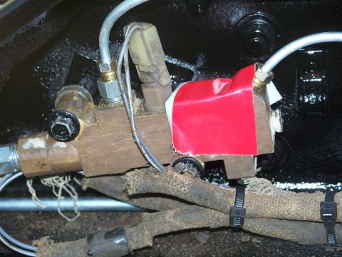 1979 Ford F-250 - Close-up of a brake proportioning valve, possibly from a truck, with visible wiring and tape.