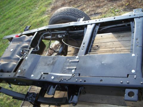 1979 Ford F-250 - The underside of a truck frame is visible, with a spare tire secured above.