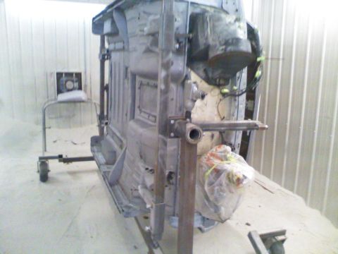 1979 Ford F-250 - The underside of a vehicle frame is suspended for work, with no clear year identification visible.