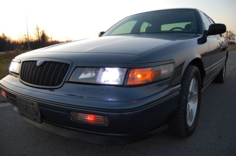 1985 Mercury Grand Marquis - A dark blue Mercury Grand Marquis is seen from the front at a 3/4 angle during sunset.