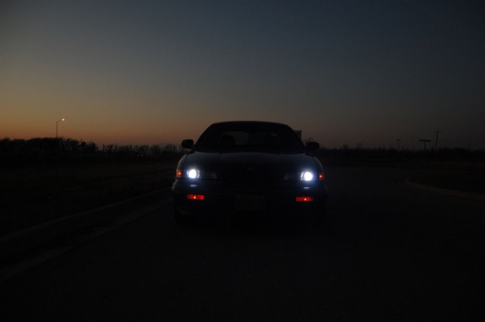 Front view of a car with headlights on during twilight
