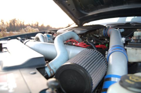 1985 Mercury Grand Marquis - The engine bay of a vehicle is shown with custom modifications and the hood is open.