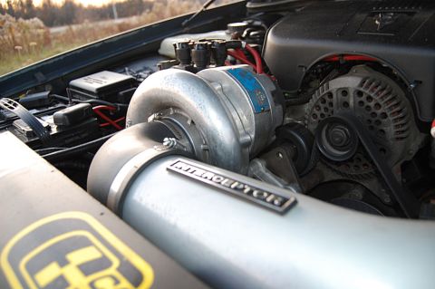 1985 Mercury Grand Marquis - Close-up of a modified engine bay a prominent turbocharger with an "INTERCEPTOR" badge.