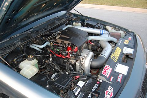 1985 Mercury Grand Marquis - Engine bay of a 1985 Mercury Grand Marquis, modified with a turbocharger and aftermarket parts.