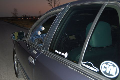 1985 Mercury Grand Marquis - A dark blue car's interior is visible through the windows, with stickers on the glass.