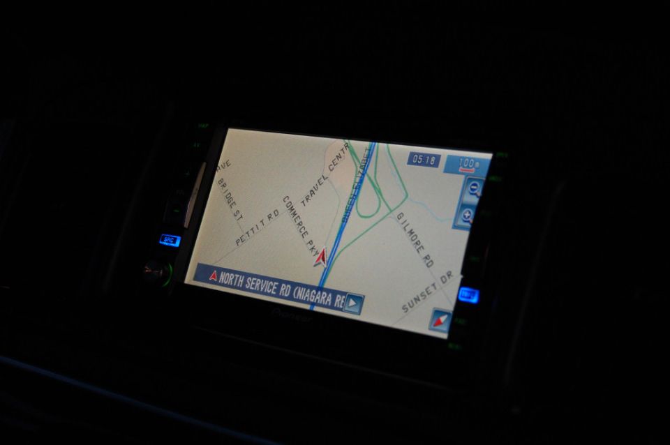 Car navigation screen displaying a map with roads like North Service Rd, Commerce Pkwy, and Gilmore Rd