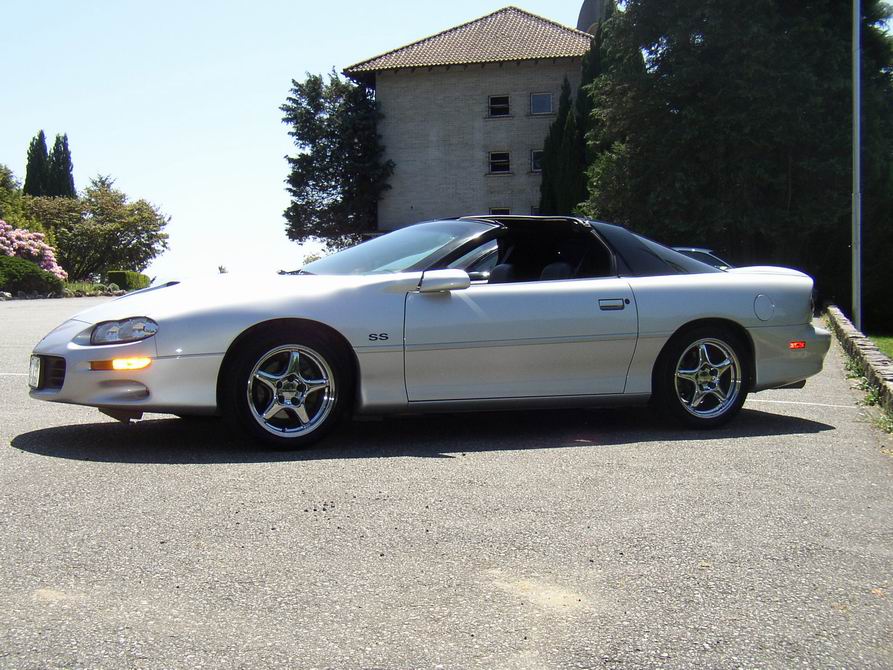 Silver Chevrolet Camaro SS coupe with a black t-top roof, parked on asphalt