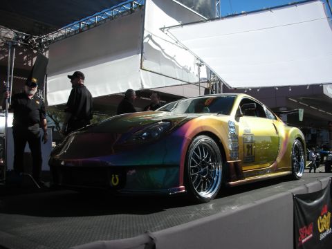 1998 Ford Crown Victoria - A customized sports car with a unique iridescent paint job is displayed at an event.
