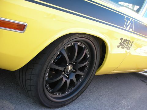 1998 Ford Crown Victoria - Close-up of a yellow muscle car's rear quarter panel, black racing stripes and custom wheels.