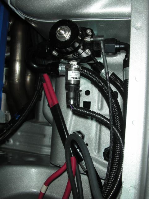 1998 Ford Crown Victoria - A close-up view of a fuel pressure regulator and sensor assembly with associated wiring and hoses.